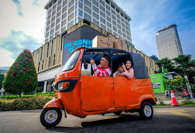 A family enjoys a city tour in Jakarta's vibrant streets, captured in a colorful tuk tuk.