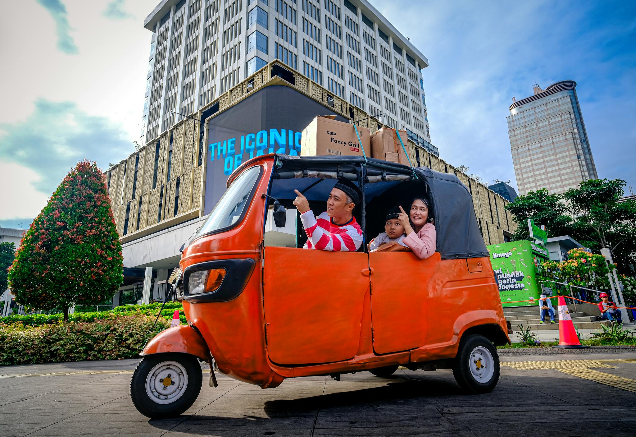 A family enjoys a city tour in Jakarta's vibrant streets, captured in a colorful tuk tuk.